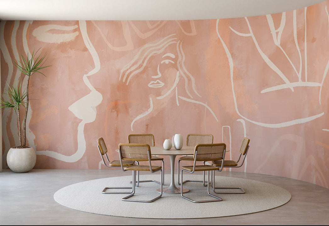 Dining area with a pink wall featuring white abstract designs, round table, and chairs from drop it MODERN.